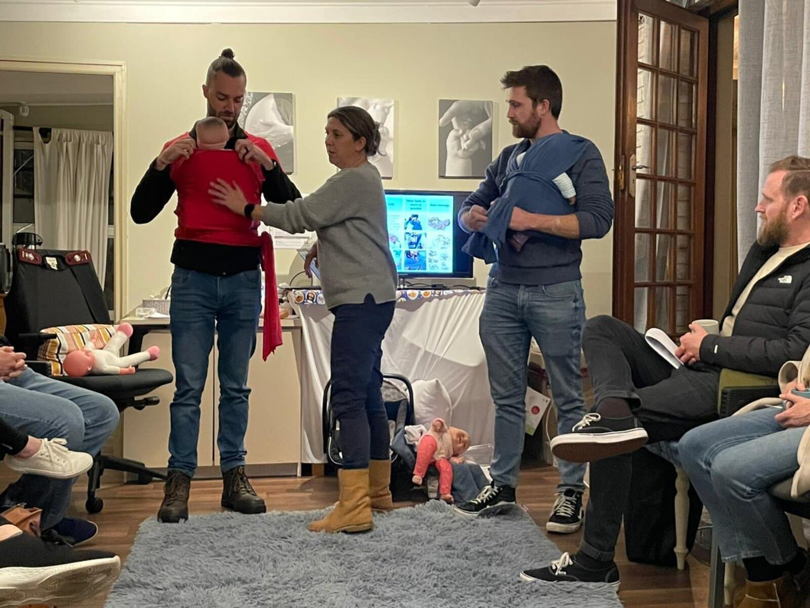 Megan teaching baby-wearing to dads in a group class
