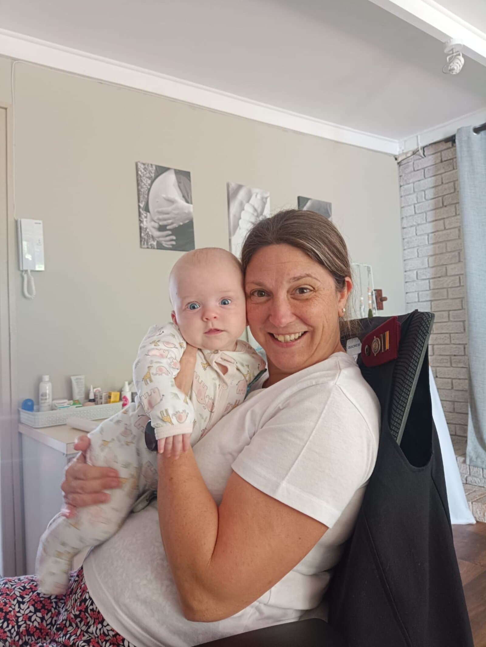 Megan smiling with a baby at the clinic