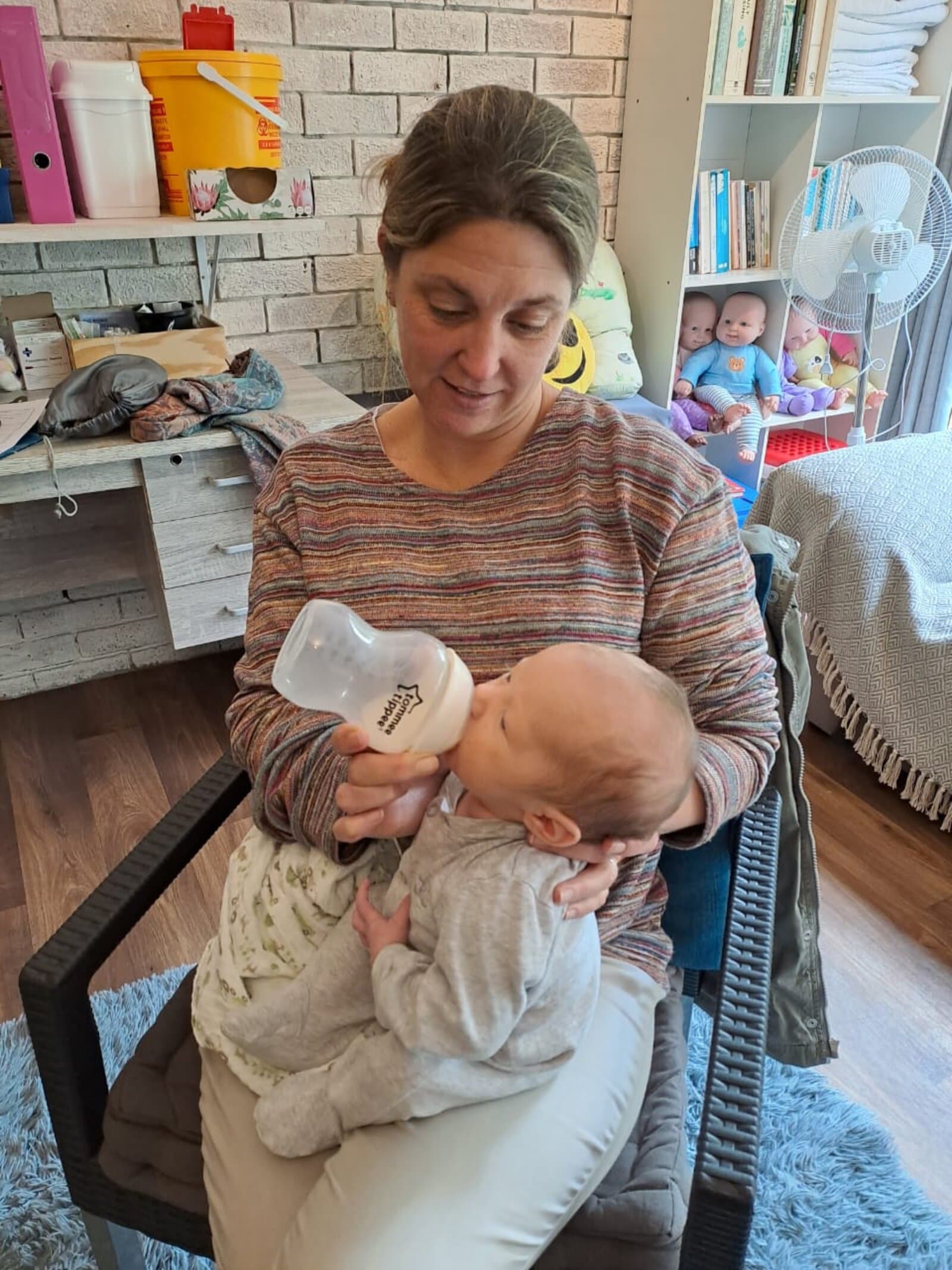 Megan bottle feeding a baby at the clinic — we support all feeding journeys