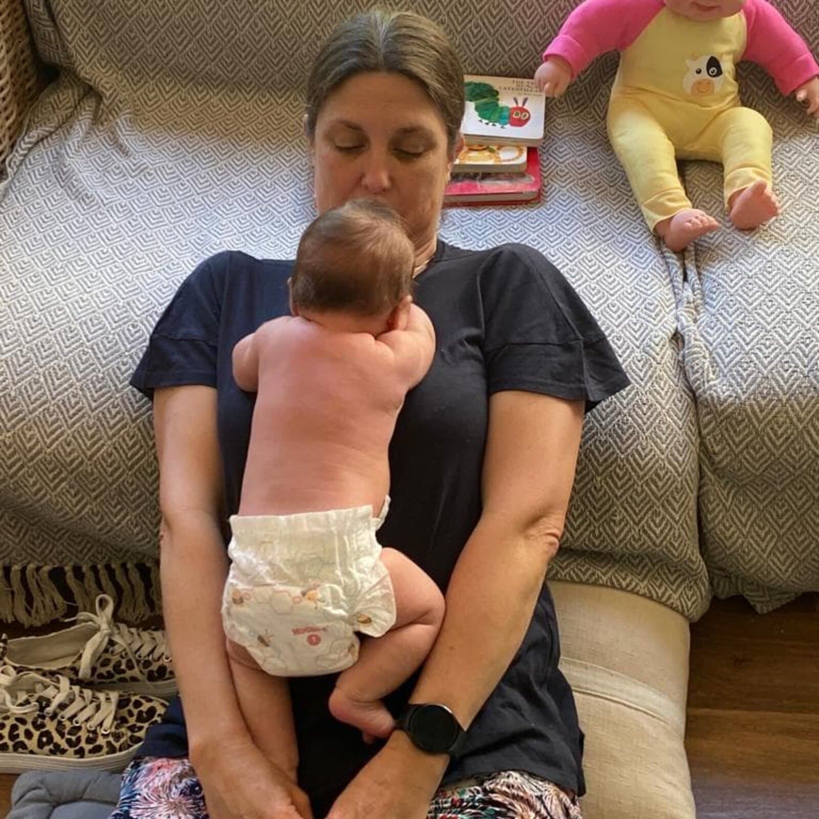 Megan cuddling a baby on the couch