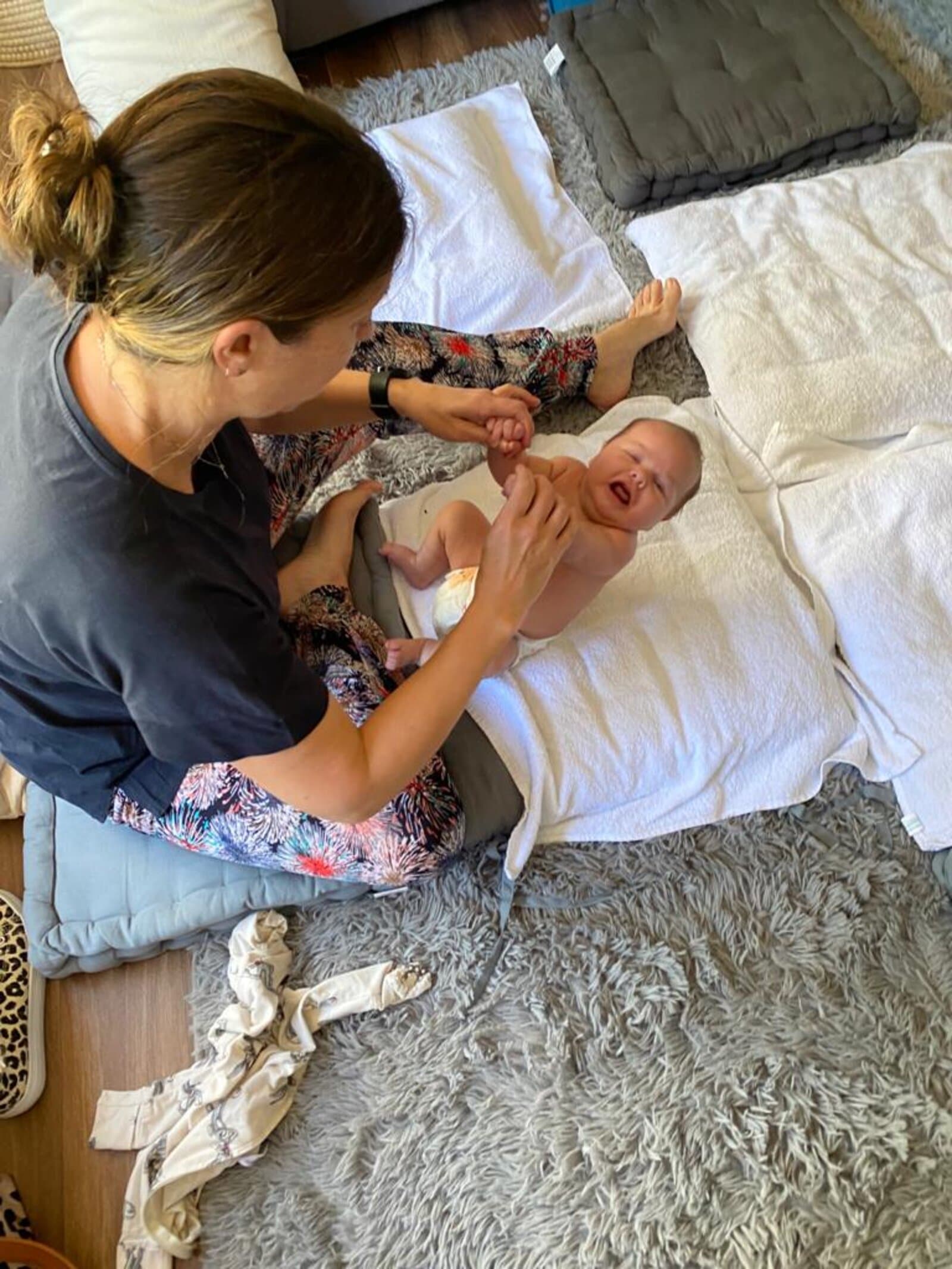 Megan massaging a laughing baby — overhead action shot